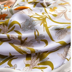 Détail d'un foulard en soie avec imprimé floral réaliste sur un tissu en sergé