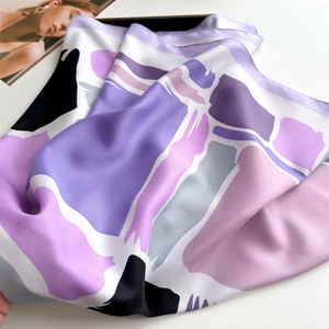 Detailed close-up of purple abstract geometric print on high-quality silk scarf fabric