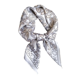 Elegant white silk scarf featuring paisley and celestial sun patterns in a stylish knot