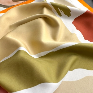Detail of luxurious twill silk scarf showing colorful colorblock patterns and fine texture