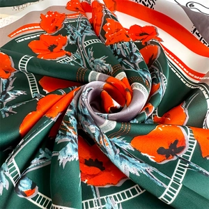 Detailed view of silk-texture square scarf featuring vibrant orange poppy flower patterns
