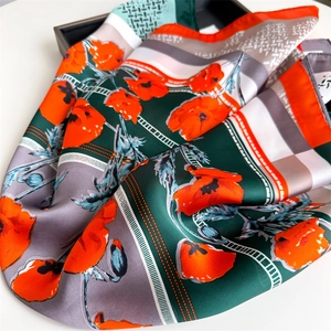 Detailed view of silk square scarf featuring orange poppy floral prints and rolled edges