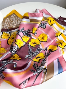 Detail of silk satin scarf showing yellow poppy flowers and pink geometric patterns