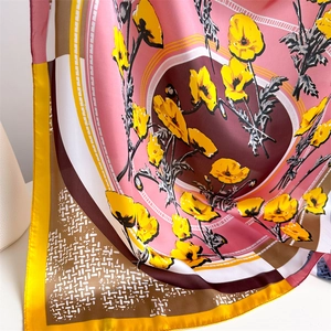 Detailed view of floral silk scarf featuring vibrant yellow poppies and colorful borders