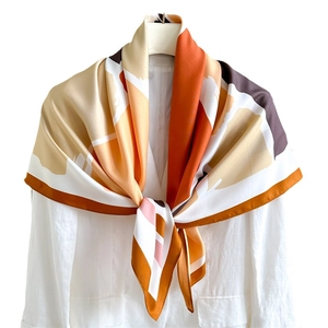Luxurious geometric color block silk scarf 90x90cm elegantly styled on a white shirt