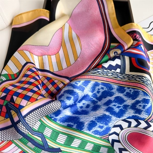 Detail of silk-like satin square scarf featuring colorful pop art graffiti and rolled edges