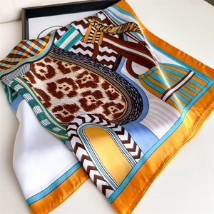 Close-up of silk-satin scarf showing vibrant orange and blue leopard geometric prints