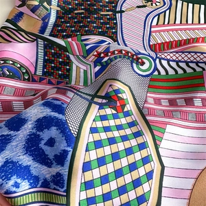Detail of silk-like scarf featuring abstract geometric graffiti patterns and smooth texture