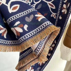 Detailed view of navy blue floral knit scarf with colorful tassel fringes and texture