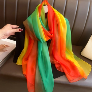 Gros plan d'un foulard en soie arc-en-ciel montrant une texture douce et dégradé éclatant