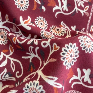 Close-up of luxury dark red cashmere scarf with intricate white and orange floral patterns