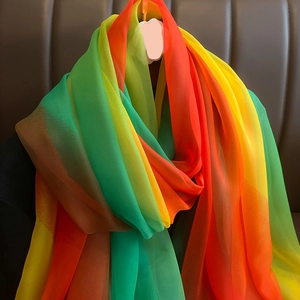 Détail d'une écharpe en soie dégradé arc-en-ciel au tissu léger et semi-transparent