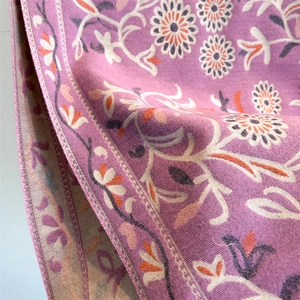 Detail of floral cashmere-like scarf showing soft purple texture and intricate flower patterns