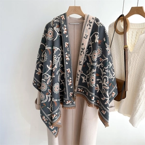 Detail of dark grey cashmere-feel shawl with floral patterns and brown fringe tassels