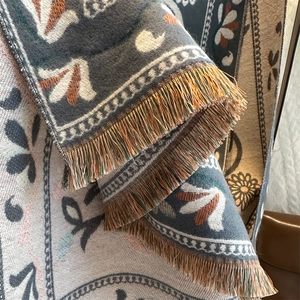 Detail of woven floral scarf with fringe edges showing thick cashmere-like texture