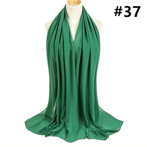 Detailed view of the emerald green chiffon shawl texture and drape on a mannequin