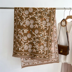 Close-up of thick cashmere-like scarf showing sunflower patterns and fringe edge details