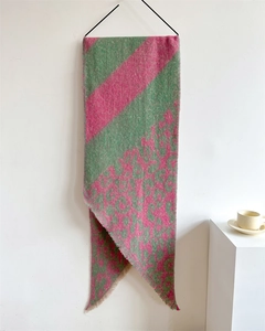 Close-up of green and pink leopard print scarf with thick loop yarn and fringe edges