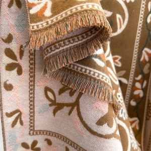 Close-up of bohemian floral cashmere-feel scarf with intricate knit and fringe detail
