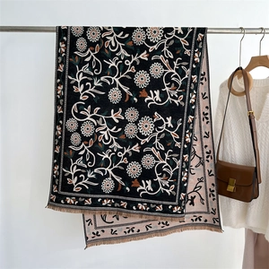 Close-up of double-sided floral cashmere-feel shawl with elegant tassels and flower patterns