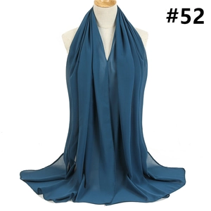 Detailed view of dark cyan chiffon shawl with fine edges draped on a mannequin