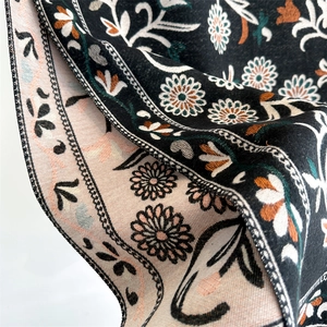 Detail of floral cashmere-like scarf showing double-sided ethnic print and soft texture