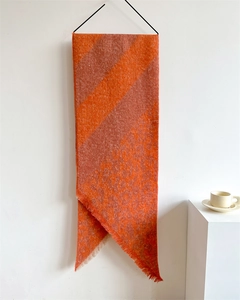 Close-up of orange and beige scarf with leopard pattern and delicate fringe details