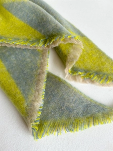 Close-up of thick checkered scarf showing soft texture and detailed fringe edges