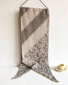 Close-up of leopard print scarf with fringe edges and warm wool-like texture