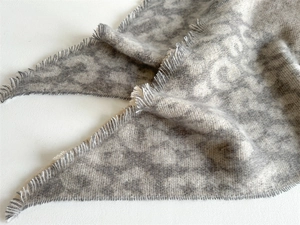Close-up of grey leopard print scarf showing soft texture and fine fringe details