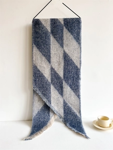 Close-up of argyle cashmere-like scarf showing soft texture and frayed tassel edges