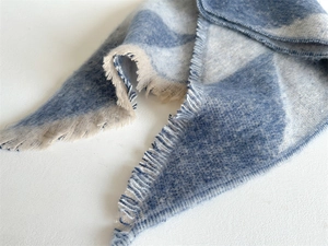 Close-up of blue and off-white checkerboard scarf showing soft fringe detail and texture