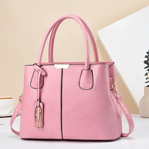 Detail of pink faux leather handbag showing fine texture and golden metal hardware