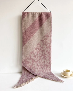 Detail of thick knit scarf with pink and grey patchwork, leopard print and fringe