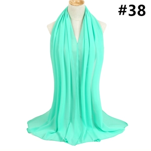 Detail of mint green chiffon shawl on mannequin showing lightweight fabric and rolled edges