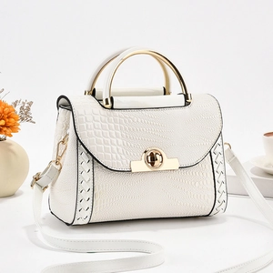 Détail du sac blanc à motif crocodile avec fermoir doré et bordure en cuir tressé