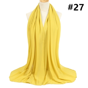 Detail showing the sheer texture and elegant drape of a yellow chiffon hijab scarf