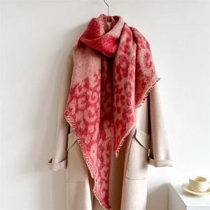 Pink leopard print scarf with tassels styled on a beige coat for a warm winter look