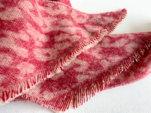 Macro detail of leopard pattern circle yarn scarf with soft frayed edges and fuzzy texture