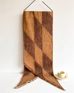 Macro view of thick brown checkerboard scarf with frayed edges and knit texture