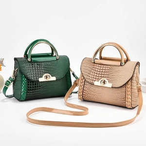 Détail de la texture croco sur sacs à main avec poignées métalliques et fermoirs dorés