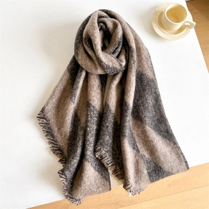 Close-up of thick plaid scarf with brown and beige checkers and soft fringed edges