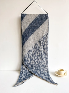 Detailed view of long navy and grey scarf with leopard print and fringe edges
