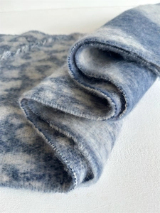 Detail of blue leopard print scarf showing soft fuzzy mohair texture and fringe edge
