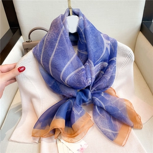Elegant large silk scarf in navy blue with white leaves and contrasting orange border