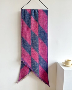 Detail view of pink and grey checkerboard scarf with thick cashmere feel and tassels