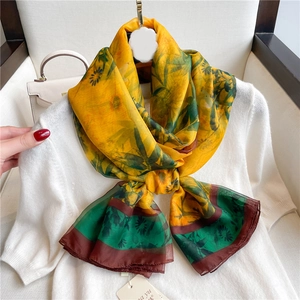 Floral print silk shawl in yellow and green with black chrysanthemum patterns on white knitwear