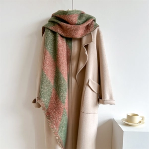 Detail of argyle knit scarf with fringe edge on beige wool coat for winter fashion