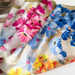 Detail shot of 90cm floral silk scarves with vibrant hand-painted patterns and green edges
