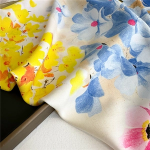 Close-up of lightweight twill silk scarf with vibrant artistic floral print and soft sheen